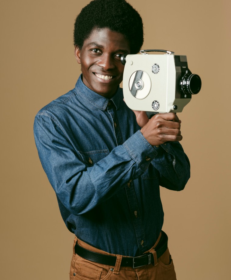 medium-shot-smiley-man-holding-old-video-camera (1)